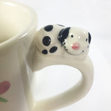 Puppy dog on handle of coffee mug